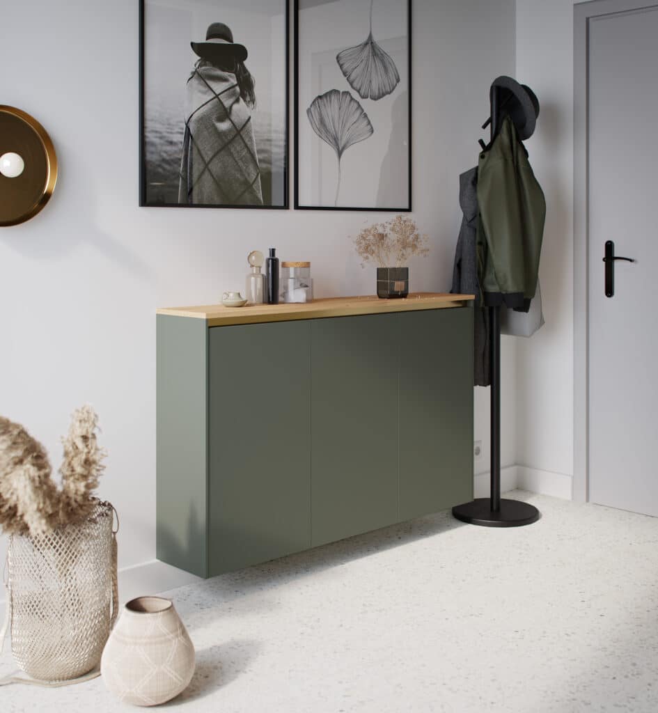 Meuble vert avec plateau en bois, décoré de vases et photos encadrées, à côté d'un porte-manteau noir avec vestes et chapeaux.