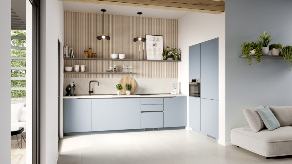 Cuisine moderne avec armoires bleues, étagères murales avec vaisselle et plantes, et canapé beige avec coussin bleu.