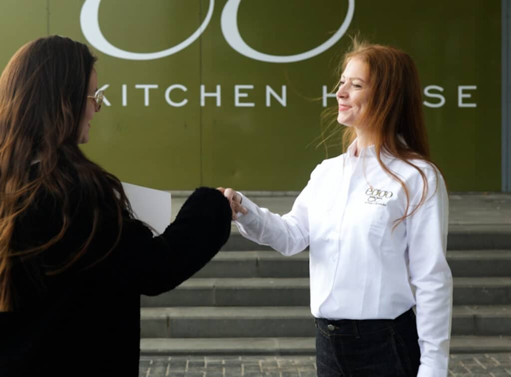 Deux femmes font une poignée de main devant èggo