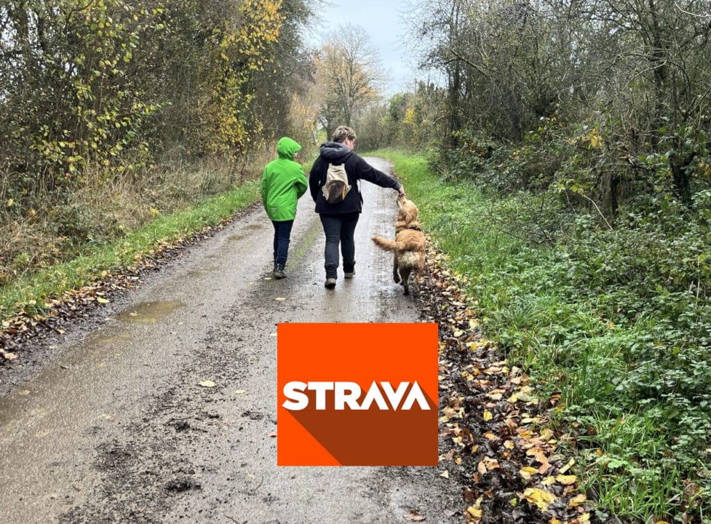 Deux personnes qui marchent sur un chemin avec un chien, avec le logo "Strava"
