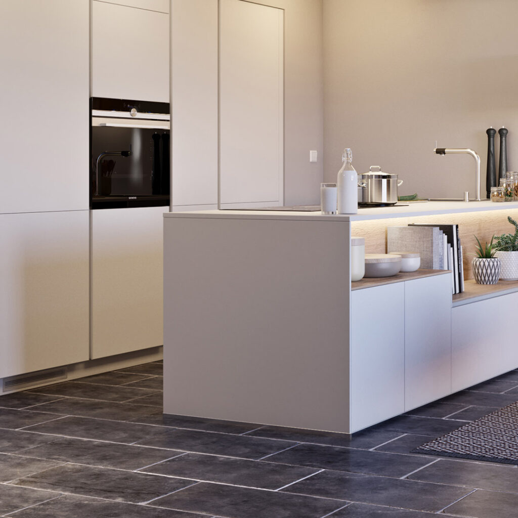 Cuisine moderne aux meubles blancs avec îlot central, four encastré noir, évier avec robinet inox et sol foncé en grands carreaux rectangulaires.
