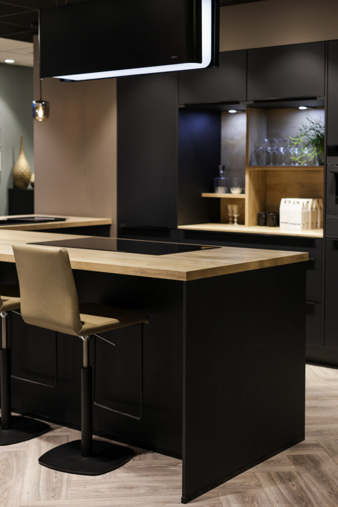 Cuisine noire moderne avec plan de travail en bois et îlot central