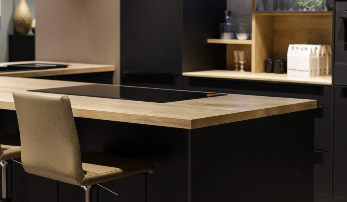 Cuisine noire moderne avec plan de travail en bois et îlot central